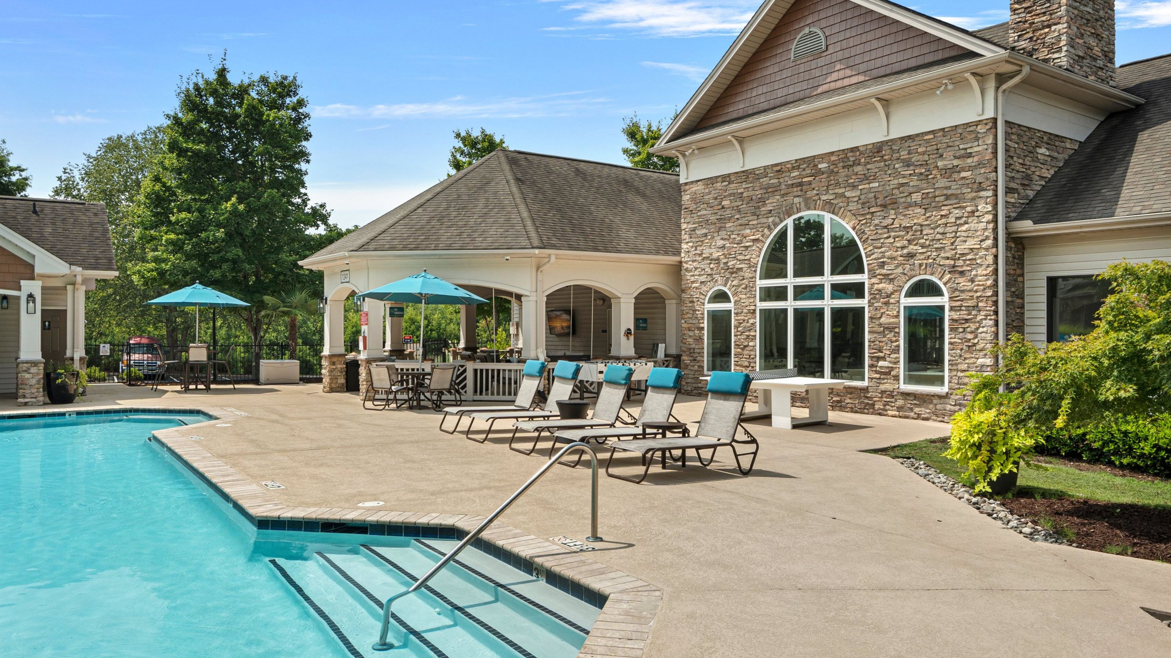 Hawthorne at the Meadows exterior building next to outdoor pool with surrounding chairs
